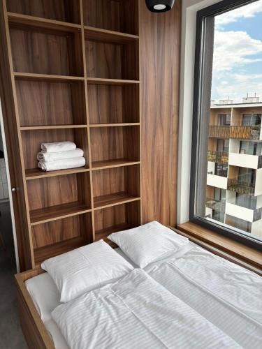 a bed in a room with a window at Magnolia Loft Apartments in Wrocław