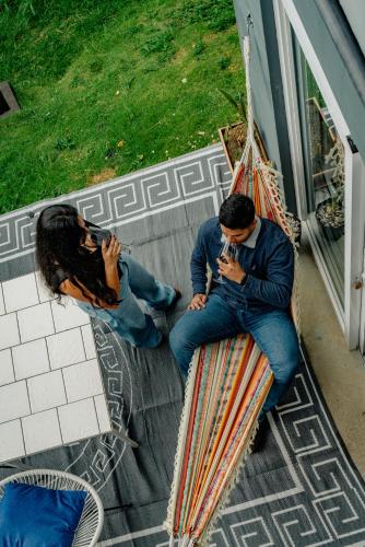 a man and woman sitting in a hammock talking on their cell phones at Casa Ejecutiva Boquete in Boquete