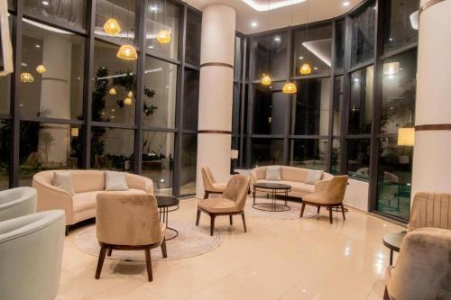 a lobby with chairs and tables and windows at Spacious 3BR Luxury Apartment Trizen Colombo 2 Near City Centre in Colombo