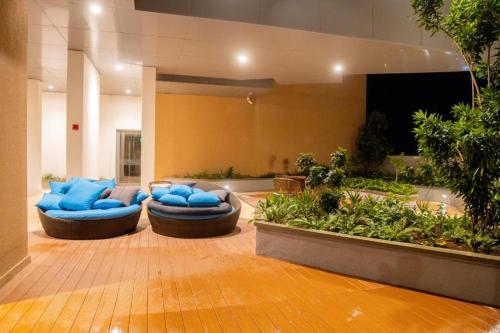a lobby with two blue couches and plants at Spacious 3BR Luxury Apartment Trizen Colombo 2 Near City Centre in Colombo