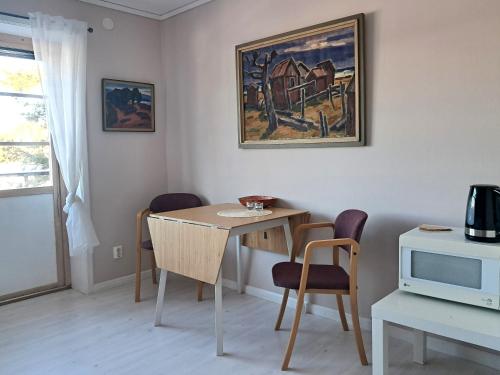 a dining room with a table and chairs and a painting at Furudals Bruk in Furudals Bruk