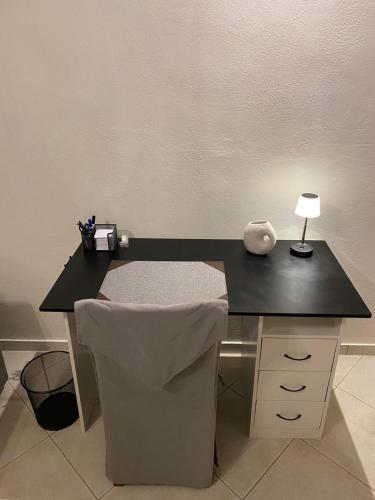 a black desk with a lamp and a chair at Deppy's House in Naousa