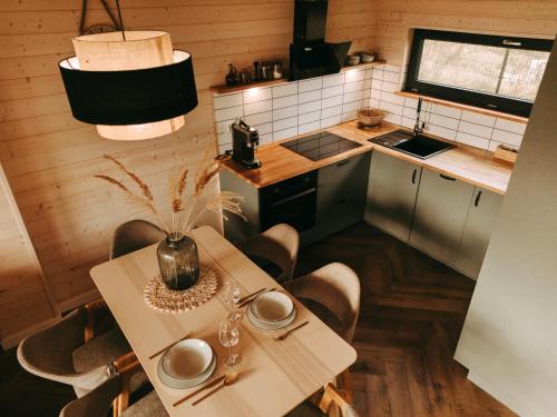 a kitchen with a table and some chairs and a counter at Wood House Trzęsacz in Trzęsacz