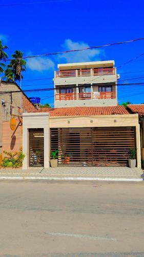 a building with two garage doors in front of a street at Japaratinga Suites in Japaratinga