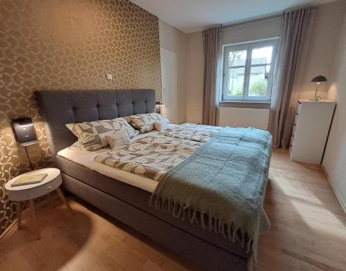 a bedroom with a large bed and a window at Holledauer Hopfakammerl in Wolnzach