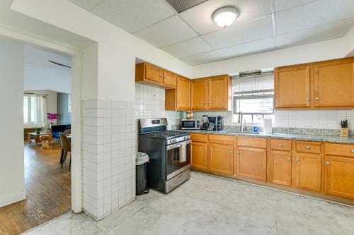 a kitchen with wooden cabinets and a stove top oven at 2 Mi to Rainbow Beach Park South Side Charmer! in Chicago