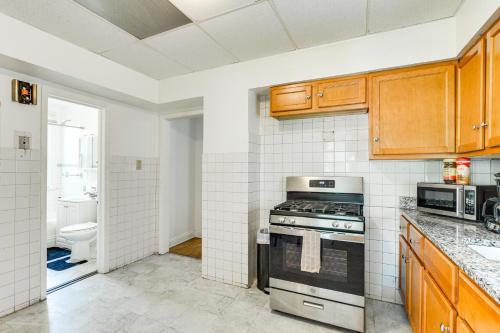 a kitchen with wooden cabinets and a stove at 2 Mi to Rainbow Beach Park South Side Charmer! in Chicago