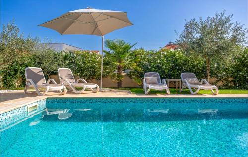 eine Gruppe von Stühlen und einem Sonnenschirm neben einem Pool in der Unterkunft Cozy Home In Pinezici With Wifi in Pinezici