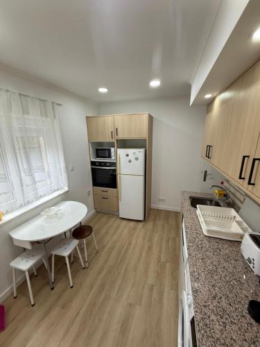 a kitchen with a white table and a white refrigerator at Baleal Atlantic Villa in Baleal