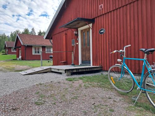 a bike parked in front of a red building at Furudals Bruk in Furudals Bruk