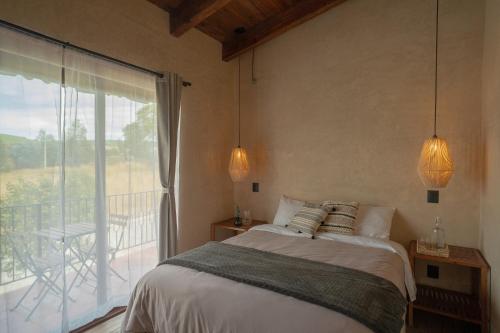 a bedroom with a bed and a balcony at Casa Xanu in Tapalpa