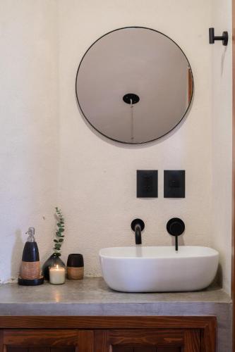 a bathroom with a white sink and a mirror at Casa Xanu in Tapalpa