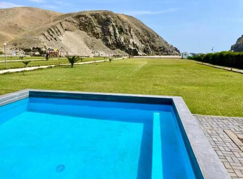 a blue swimming pool with a mountain in the background at Casa de Playa frente al mar en Chocalla, Asia in Asia