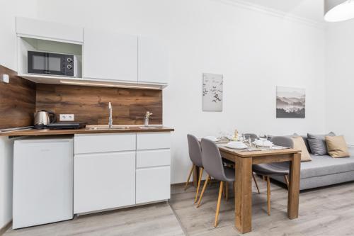 a kitchen and dining room with a table and a couch at Stylish Natural Studio Central Budapest in Budapest