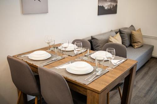 a dining room table with plates and wine glasses at Stylish Natural Studio Central Budapest in Budapest