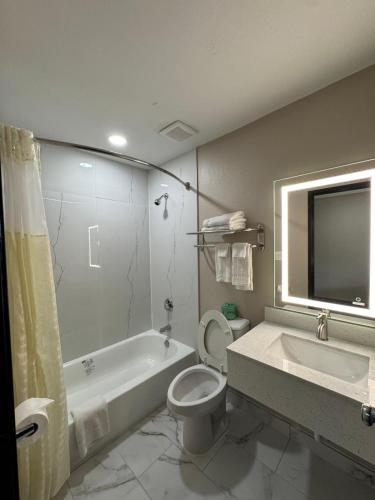 a bathroom with a tub and a toilet and a sink at Texarkana Inn in Texarkana