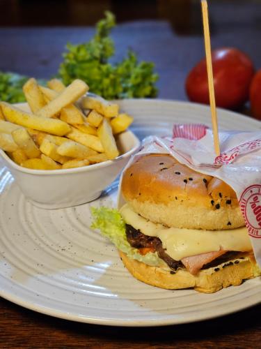 a white plate with a sandwich and french fries at Hotel Finca Recreacional La Fortaleza 