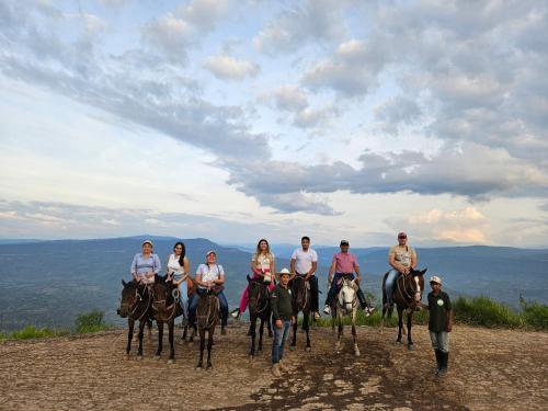 a group of people riding horses on a hill at Hotel Finca Recreacional La Fortaleza 