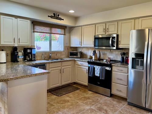a kitchen with white cabinets and stainless steel appliances at Osborn Oasis | Short Walk to Old Town Scottsdale in Scottsdale