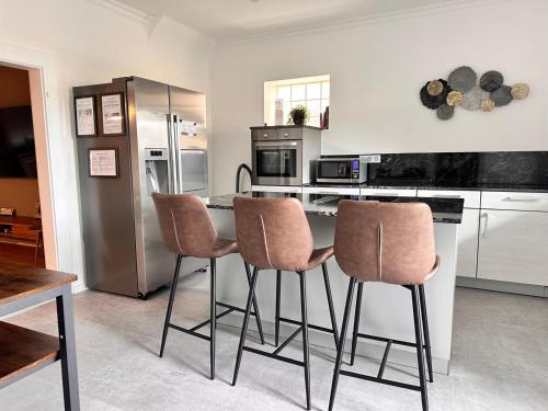 a kitchen with a table and four bar chairs at 80qm Luxus Apartment mit großer Terrasse in Saarbrücken