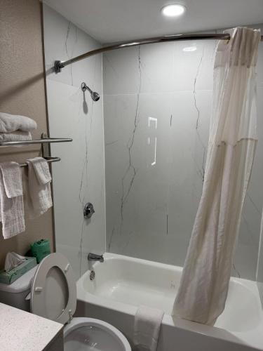 a bathroom with a shower and a toilet and a sink at Texarkana Inn in Texarkana
