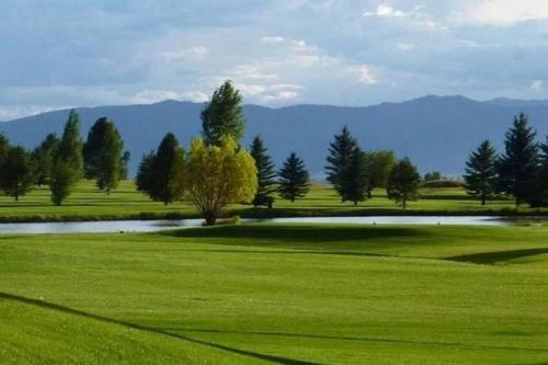 a golf course with a pond in the middle of a field at Aspen Serenity - Hiking - in the Teton Valley in Driggs