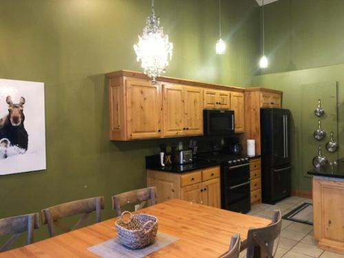 a kitchen with a wooden table and a dining room at Aspen Serenity - Hiking - in the Teton Valley in Driggs