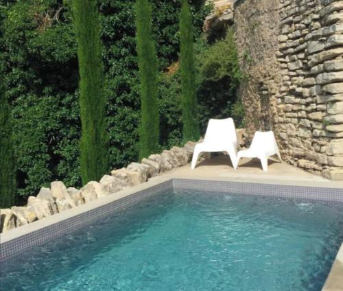 - deux chaises blanches installées à côté de la piscine dans l'établissement Maison d exception au coeur de Goult avec piscine privée et vue panoramique, à Goult