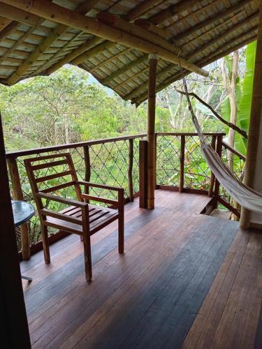 a porch with a chair and a hammock on it at Refugio Cumaná Entero in San Rafael