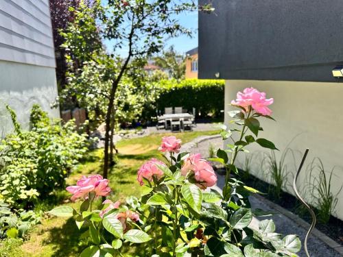 a garden with pink flowers next to a building at 80qm Luxus Apartment mit großer Terrasse in Saarbrücken