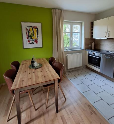 a kitchen with a wooden table and chairs in a room at Holledauer Hopfakammerl in Wolnzach