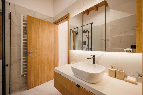 a bathroom with a white sink and a mirror at Aqua Thermal Villa Banya in Banya