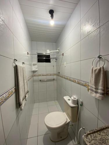 イポジュカにあるSuíte Maracaのトイレと洗面台を備えた白いバスルーム