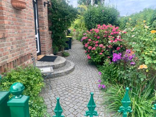 a garden with flowers and a brick walkway at Reeser Schatzkästchen in Rees