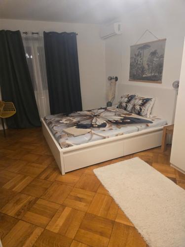 uma cama em um quarto com piso de madeira em Séjour calme près du Léman em Mies