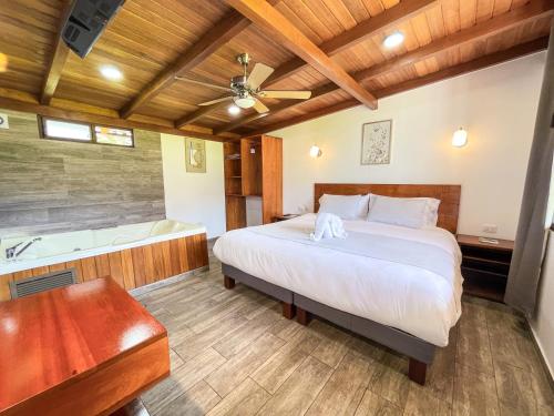 a bedroom with a bed and a bath tub at Royal River Suites & Spa Aparthotel in Mindo