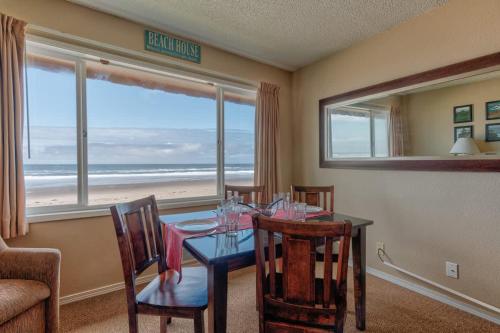 a dining room with a table and a view of the beach at Comfy Second Floor Beachfront Condo - Sleeps 4 - Pool and Sauna in Lincoln City