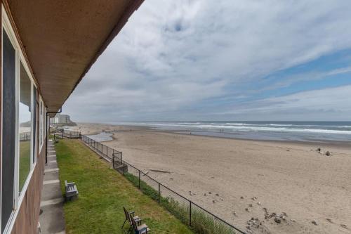 a view of the beach from the balcony of a house at Comfy Second Floor Beachfront Condo - Sleeps 4 - Pool and Sauna in Lincoln City