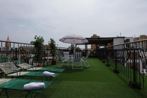 a patio with chairs and an umbrella on a balcony at Hotel Don Pedro De Heredia in Cartagena de Indias