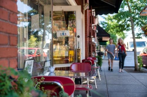 a woman walking down a sidewalk in front of a store at Forest Studio Oasis - Mile from Multnomah Village in Portland