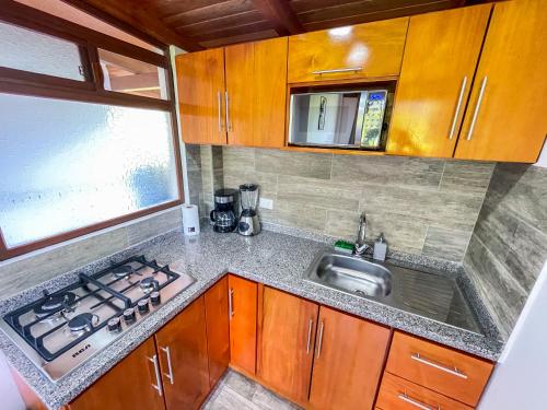a small kitchen with a sink and a stove at Royal River Suites & Spa Aparthotel in Mindo