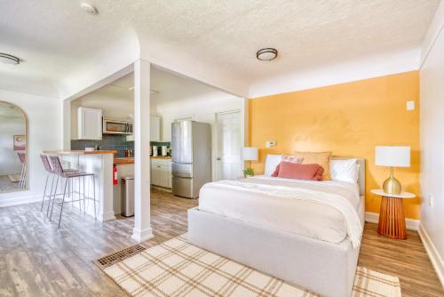 a bedroom with a white bed and a kitchen at Forest Studio Retreat - Near Multnomah Village in Portland