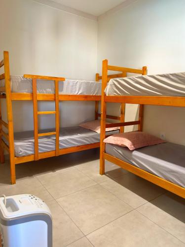a room with three bunk beds and a trash can at Refúgio Gourmet com Piscina Privativa in Nova Odessa