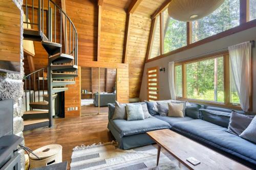 a living room with a blue couch and a wooden ceiling at Modern A-Frame Cabin in the Woods in Rhododendron