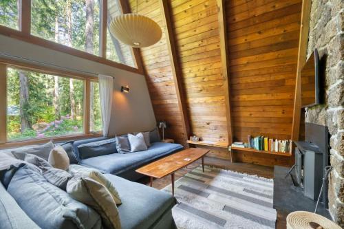 a living room with a blue couch and a table at Modern A-Frame Cabin in the Woods in Rhododendron