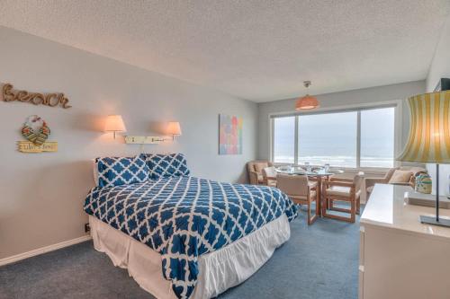 a bedroom with a bed and a dining room with a table at Beachy Second Floor Beachfront Suite With Full Kitchen - Sleeps 4 - Pool and Sauna in Lincoln City