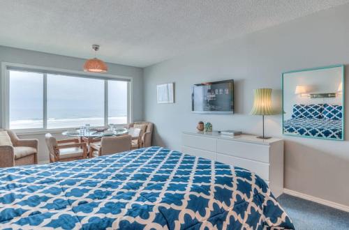 a bedroom with a bed and a dining room with a table at Beachy Second Floor Beachfront Suite With Full Kitchen - Sleeps 4 - Pool and Sauna in Lincoln City