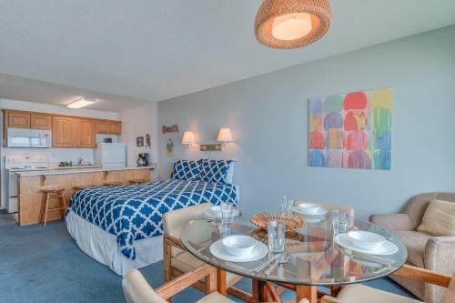 a bedroom with a bed and a table in a room at Beachy Second Floor Beachfront Suite With Full Kitchen - Sleeps 4 - Pool and Sauna in Lincoln City