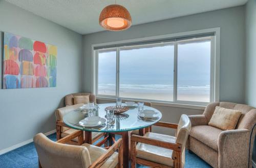 a dining room with a table and chairs and a window at Beachy Second Floor Beachfront Suite With Full Kitchen - Sleeps 4 - Pool and Sauna in Lincoln City