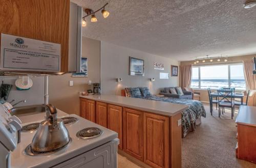 a kitchen and living room with a couch and a bed at Top Floor Condo With Amazing Views Pool and Sauna in Lincoln City